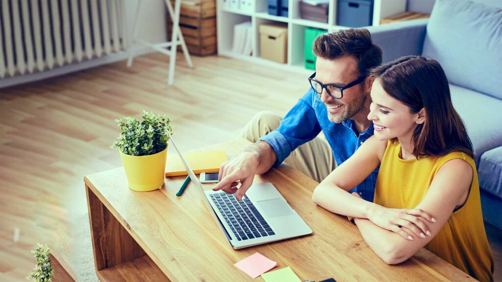 Paar vergleicht Internet-, TV- und Telefonieangebote am Laptop – neutrale Providerberatung auf dem Glasfasernetz von Baden4net in Baden und Ennetbaden